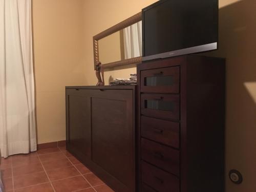 a tv on top of a dresser with a mirror at Casa Rural Parajes del Júcar in Casas de Benítez