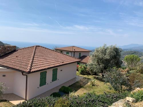 a white house with green windows and a roof at Antico Principato di Seborga in Vallebona