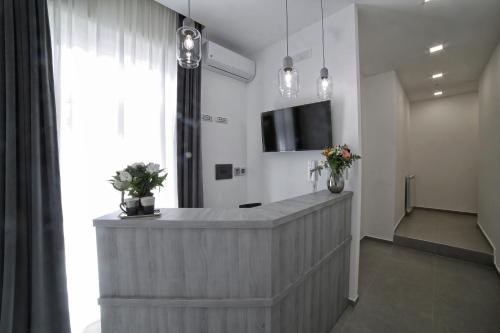 a lobby with a reception counter with a tv and flowers at Le Corti del Re in Naples