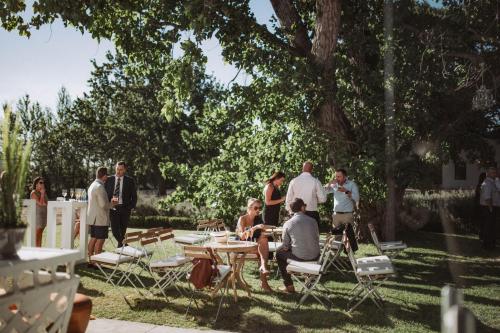 a group of people sitting around a table in the grass at La Paris Estate in Franschhoek