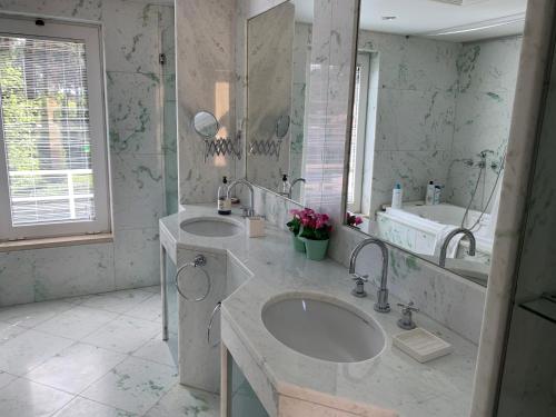 a bathroom with two sinks and a large mirror at Aroeira Villa near Lisbon- Daydream PT in Charneca