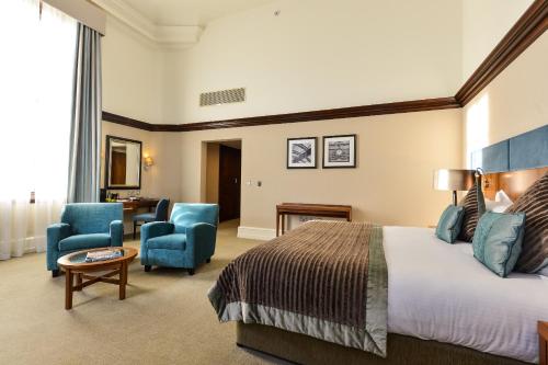 a hotel room with a bed and two chairs at The Grand, York in York