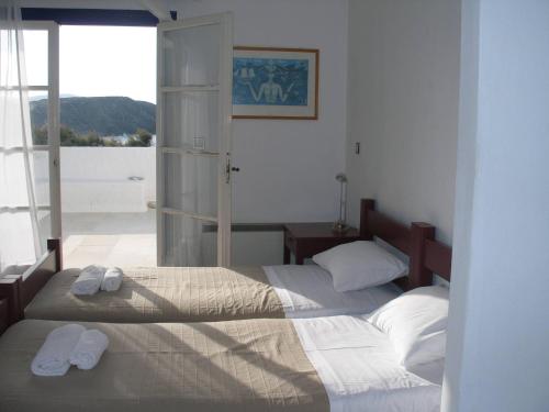 two beds in a bedroom with towels on them at Beach Villa Akrotiri in Engares