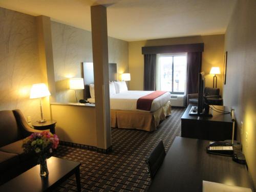 um quarto de hotel com uma cama e um sofá em Holiday Inn Express & Suites Butler, an IHG Hotel em Butler