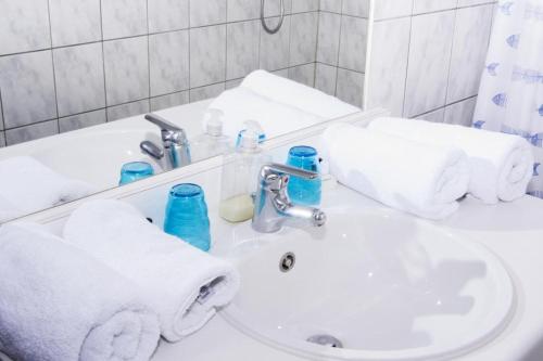lavabo blanco con toallas y espejo en Camping village SY, en Ferrières