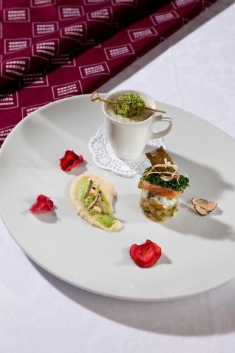 a plate with a cup of tea and some food at Haller's Geniesserhotel in Mittelberg