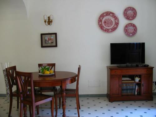 uma mesa de jantar com uma televisão, uma mesa e cadeiras em Casa Licosa em Castellabate