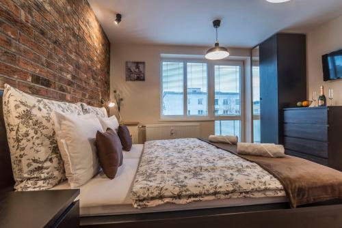 1 dormitorio con 1 cama grande y pared de ladrillo en Amos Apartment en Košice