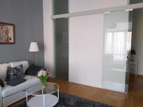 a living room with a couch and a glass table at Apartment MUSIKVIERTEL in Leipzig