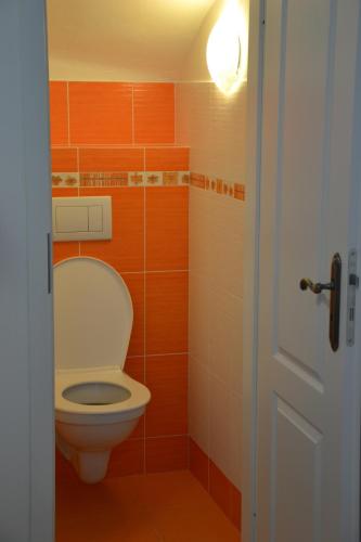 a bathroom with a toilet with orange and white tiles at Apartmány Ski Lift in Rokytnice nad Jizerou