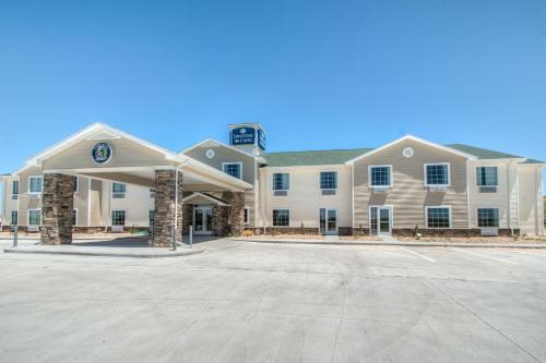 Un gran edificio con un estacionamiento enfrente. en Cobblestone Inn & Suites - Wray, en Wray