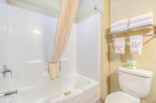 e bagno con servizi igienici, vasca e asciugamani. di Cobblestone Inn & Suites - Wray a Wray