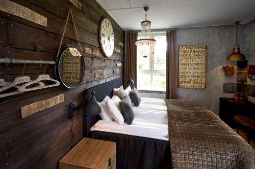 a bedroom with a bed and a clock on the wall at Karstorp Säteri – Hotell och Konferens in Skövde