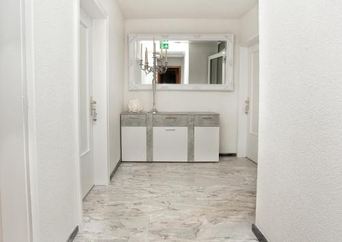 a hallway with a tile floor and a mirror at Zur Linde in Mainzweiler