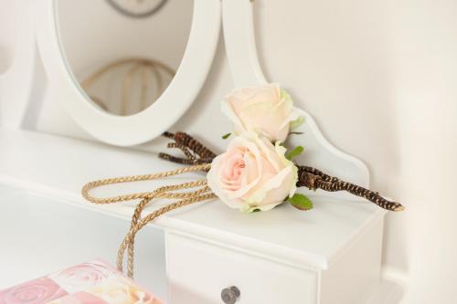 a pink rose on a white dresser with a mirror at Zur Linde in Mainzweiler