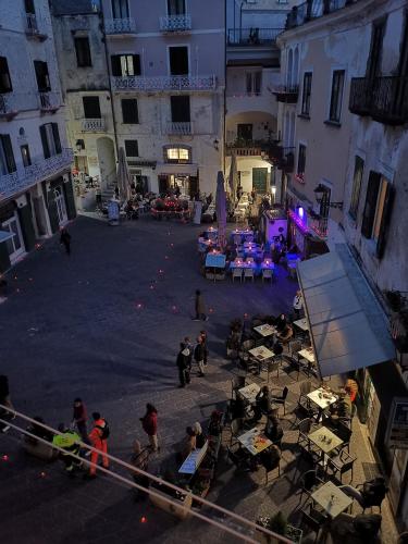 a group of people sitting around tables in a courtyard at La finestra sul borgo in Atrani