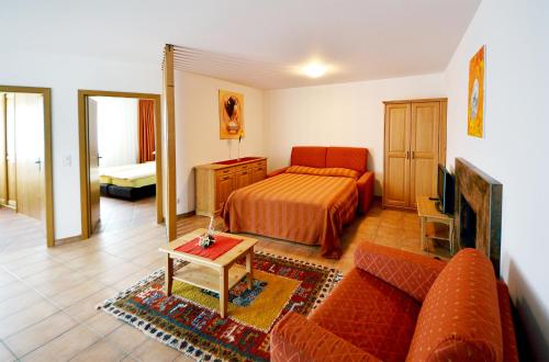 a living room with a bed and a couch at Hotel-Aparthotel San Bernardino in San Bernardino