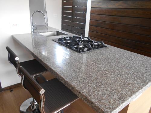 eine Küche mit einem Waschbecken und einer Granitarbeitsplatte in der Unterkunft Moderatto Suites in Medellín