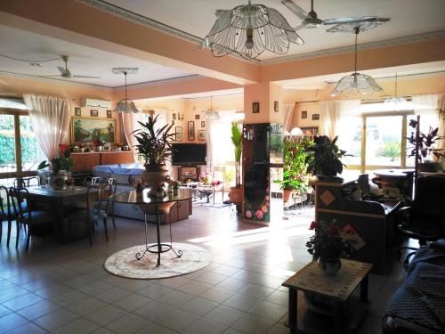 ein Wohnzimmer mit Tischen und Stühlen sowie ein Esszimmer in der Unterkunft Hotel Eliseo in Giardini-Naxos