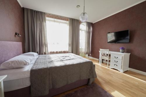 a bedroom with a bed and a tv on a wall at Rohuaia Apartments in Rakvere