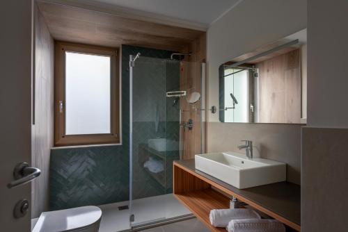 a bathroom with a sink and a glass shower at Residence Lido Hotel in Malcesine