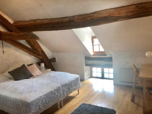 - une chambre mansardée avec un lit et une table dans l'établissement Maison de Melin, à Auxey-Duresses