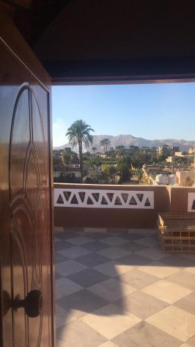 a door to a balcony with a view of the desert at The Brown House in Luxor