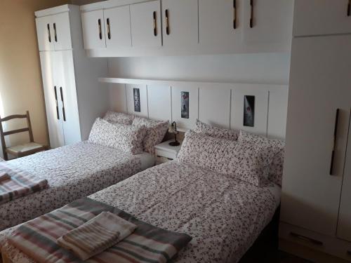two beds in a room with white cabinets at Apartamento Estación Enológica in Haro