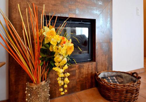a vase filled with yellow flowers in a room at Hotel-Aparthotel San Bernardino in San Bernardino