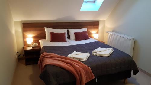 a bedroom with a large bed with two towels on it at U Podnóża Zamku in Szczytna