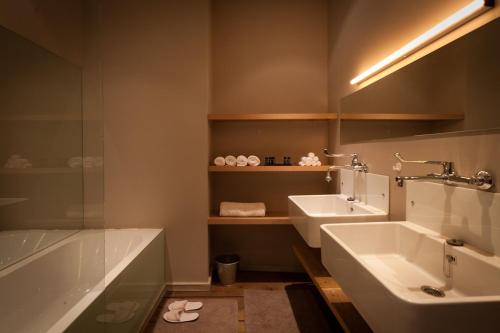 uma casa de banho com 2 lavatórios e uma banheira em Loft O - River View em Antuérpia