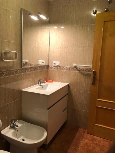a bathroom with a sink and a toilet and a mirror at Santiago VI in Guardamar del Segura