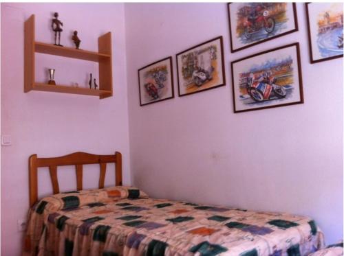 a bedroom with a bed and pictures on the wall at Santiago VI in Guardamar del Segura