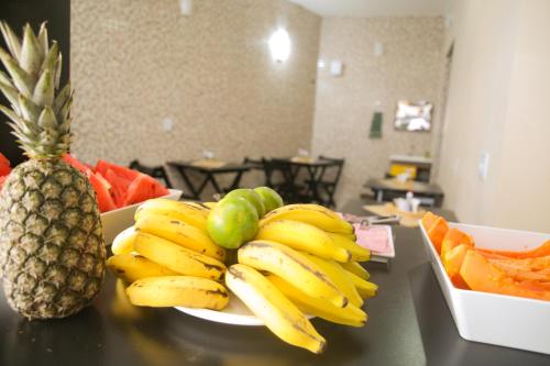 a plate of bananas and a pineapple on a counter at Hotel Hot Brás in Sao Paulo