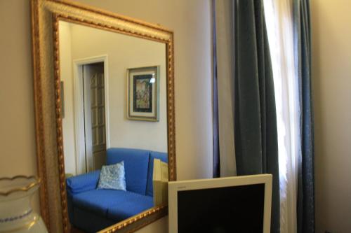a mirror reflecting a blue couch in a room at Villa Clementine in Piazza Armerina