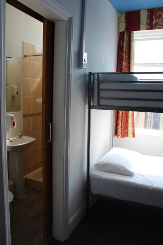 Ένα ή περισσότερα κρεβάτια σε δωμάτιο στο Backpackers Blackpool Hotel & Suites