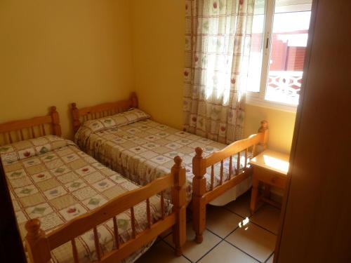 罗列特海岸法马拉公寓的一间带窗户的小卧室里有两张床