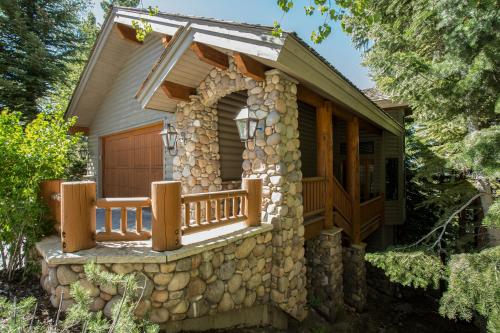 ein Steinhaus mit einer Veranda und einer Steinmauer in der Unterkunft Deer Valley's Signature Collection in Park City