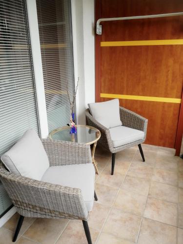 a porch with two chairs and a table and a door at Apartment Maja Moravske Toplice in Moravske Toplice