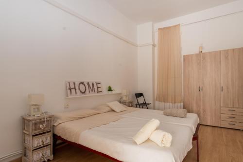 a bedroom with a large bed with a home sign on the wall at Big Flat at center of Valencia. WIFI in Valencia