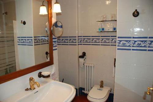 a bathroom with a sink and a toilet and a mirror at Crisol Conde Rodrigo in Ciudad-Rodrigo