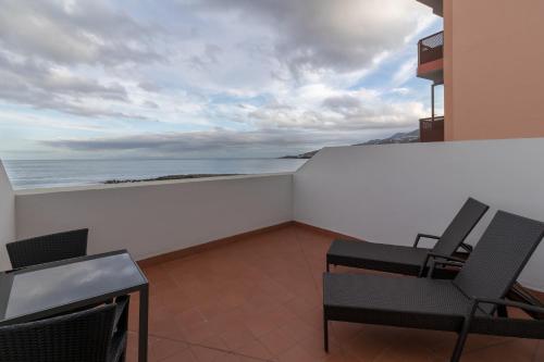 a balcony with chairs and a view of the ocean at Hotel Emblemático Holiday Time in Santa Cruz de la Palma