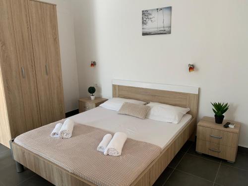 a bedroom with a bed with two towels on it at Guesthouse Orlović in Budva