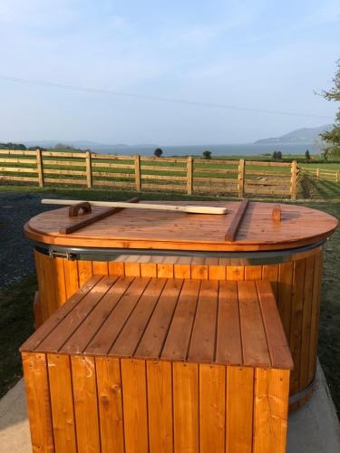 a wooden hot tub sitting next to a fence at Oakwell holiday village in Ramelton