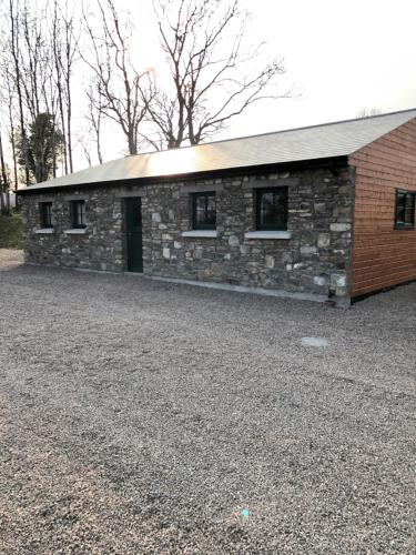 a stone building with a roof on a gravel lot at Oakwell holiday village in Ramelton