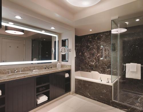 a bathroom with a tub and a sink and a shower at Delano Las Vegas at Mandalay Bay in Las Vegas