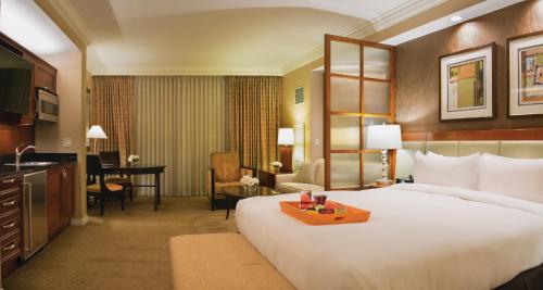 Habitación de hotel con cama grande y escritorio. en The Signature at MGM Grand - All Suites, en Las Vegas