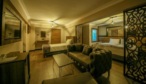 a hotel room with a couch and a bed at Fidanoglu Suite Hotel in Kesan