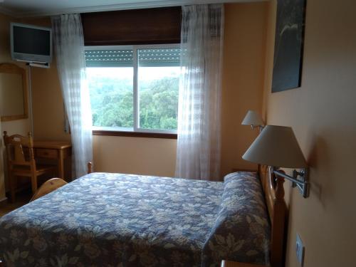 sypialnia z łóżkiem i oknem w obiekcie Hospedaje O Canizo w mieście Hio