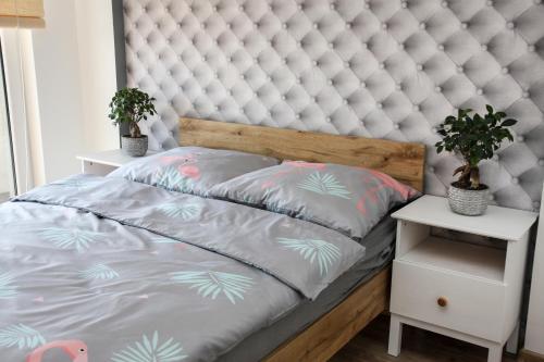 a bed with a tufted headboard with two plants at Casa de Rosa in Zator